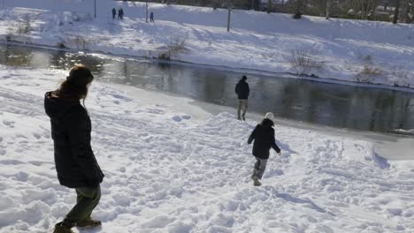 people walking downhill towards a river