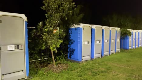 row of portable toilets in a park setting