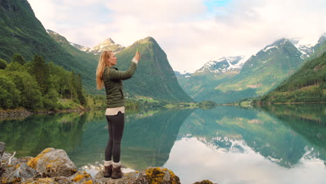 woman taking photo of a norwegian fjord landscape