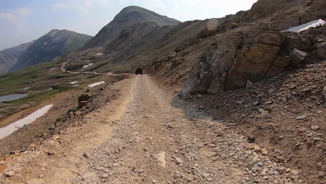 driving on black bear pass trail past pond in mineral basin