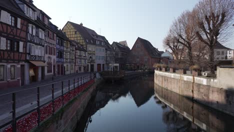 wide view of the la lauch tiver flowing through the medieval town of colmar with half-timbered houses