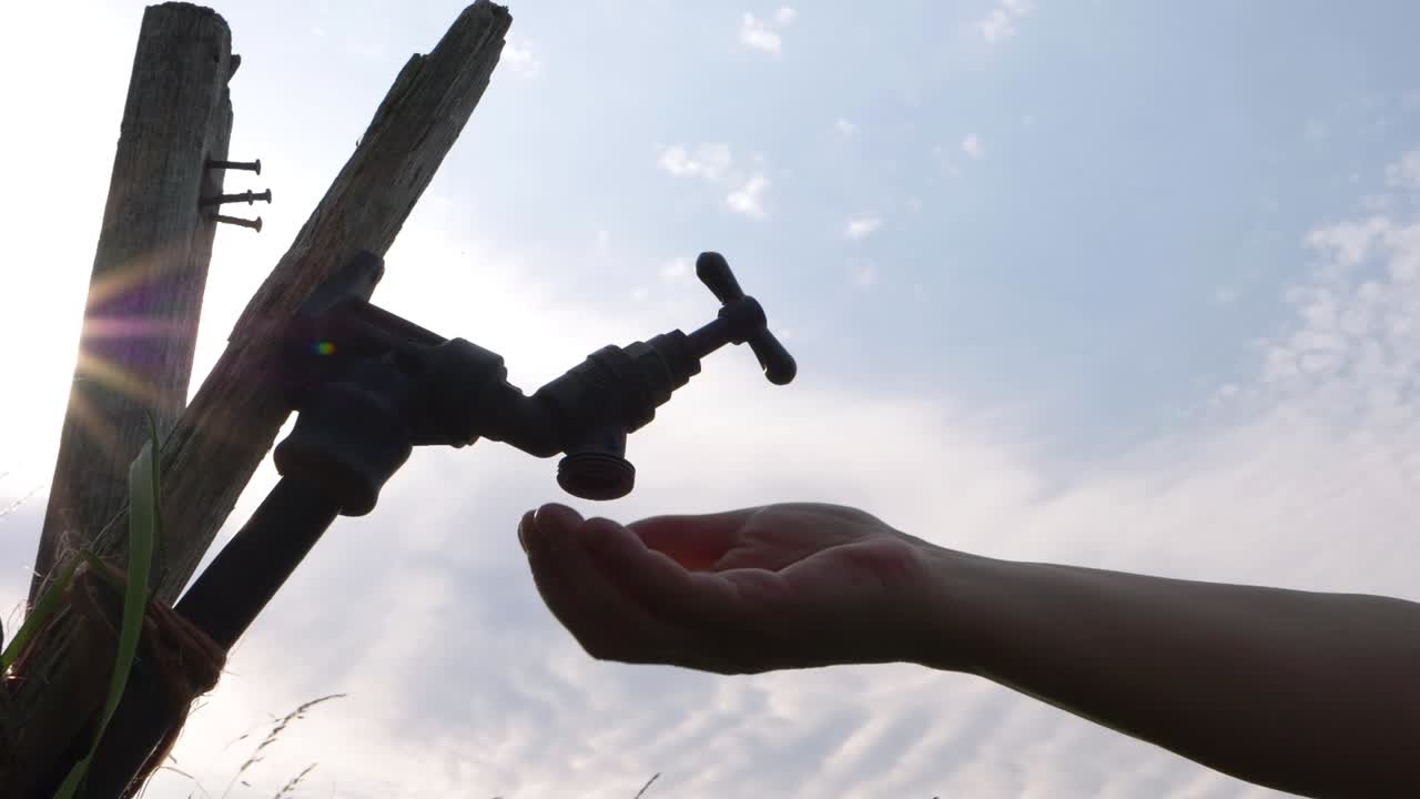Water shortage hands trying to get water from empty faucet tap medium shot