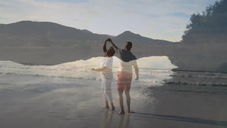 mature man and senior woman dancing barefoot with waves, showing animated heart icon for health