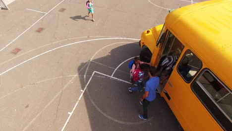 teacher giving high to kids while entering in bus