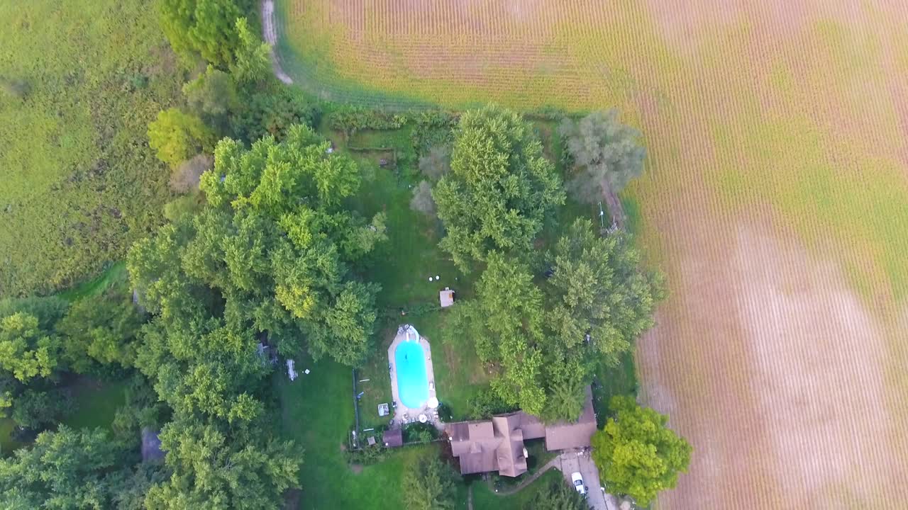 Aerial view a house in the country with fields surrounding it in 4K