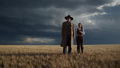 father and daughter in a wheat field under a stormy sky