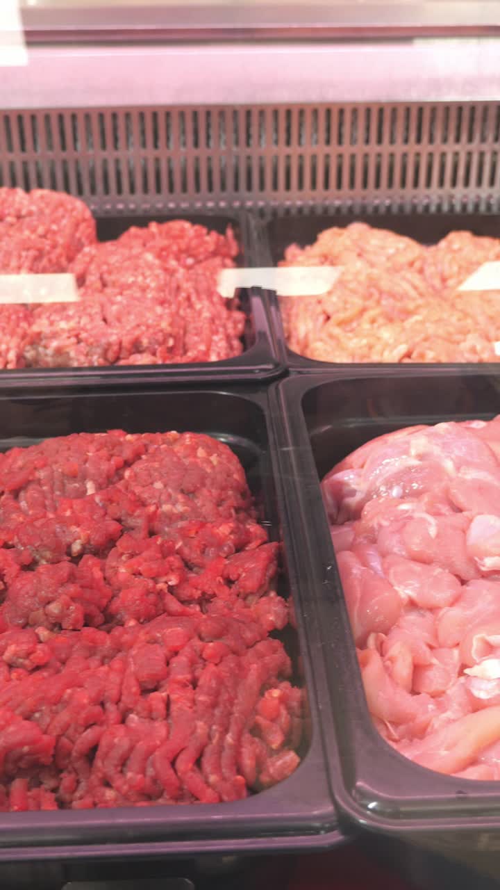 Fresh ground meat displayed in a refrigerated case, showcasing various textures and colors, highlighting quality and freshness for culinary use