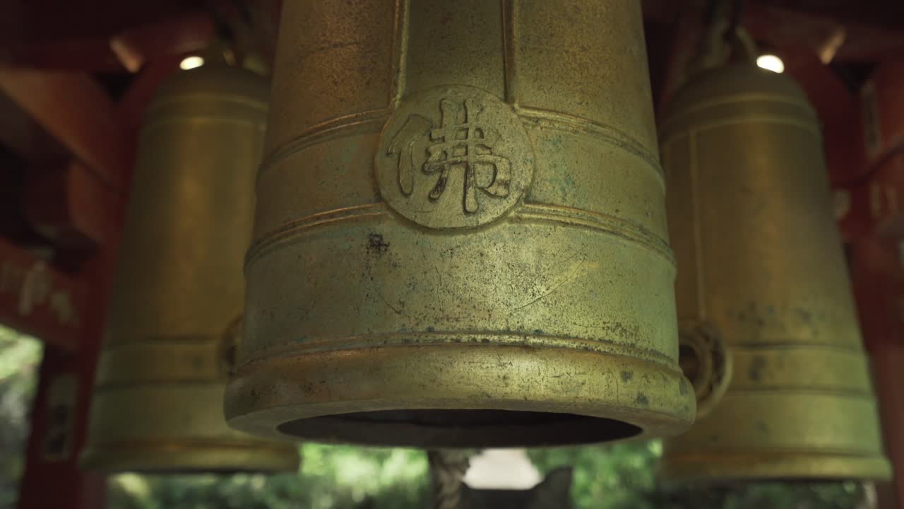A closeup shot of Golden bells hanging  in a Buddhist temple in Kyoto, Japan