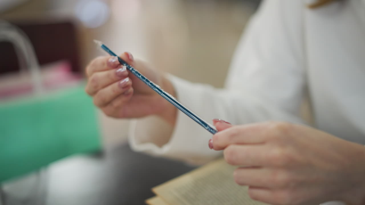 푸른 을 들고 있는 손의 클로즈업, 배경에는 민트와 녹색 쇼핑 가방이 있는 흐릿한 쇼핑 장면이 있습니다.