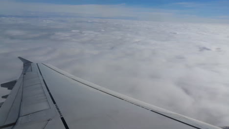 view from the window of an airplane flying above storm clouds