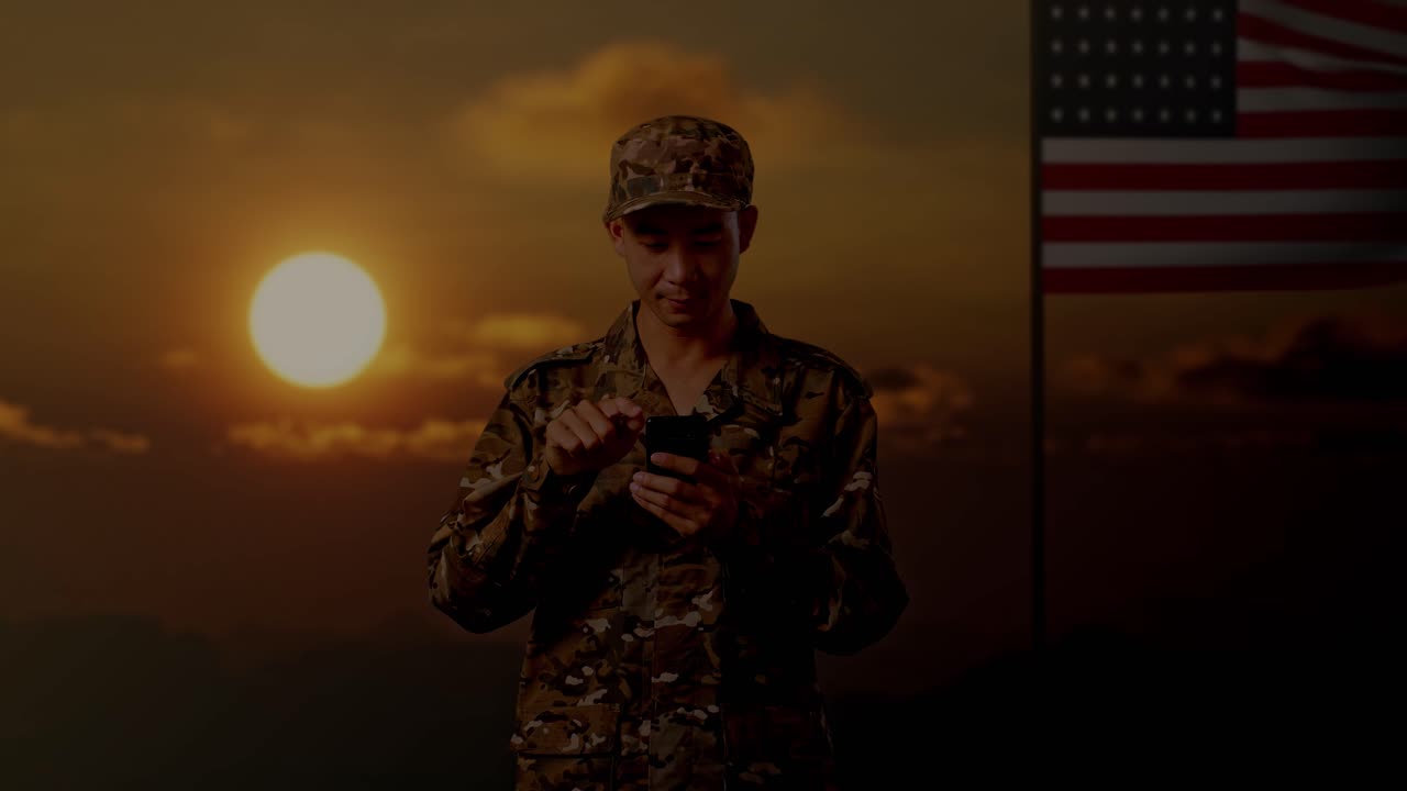 Soldato che usa lo smartphone al tramonto