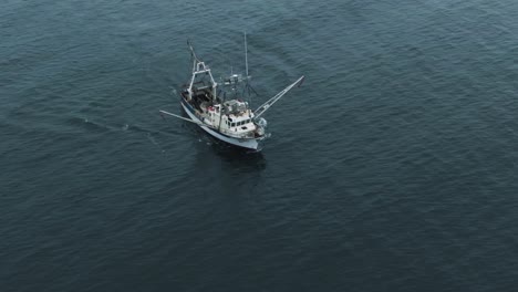 fishing trawler heads out and sailing on the calm waters of saint lawrence river in quebec, canada