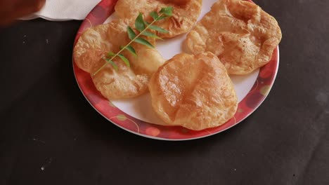 rotación chole bhature o curry de garbanzos y puri frito servido en vajilla de terracota sobre fondo negro
