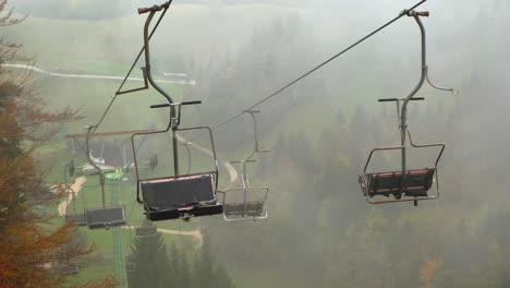 old spooky rusty chairlift sitting still at abandoned ski resort in summer fog