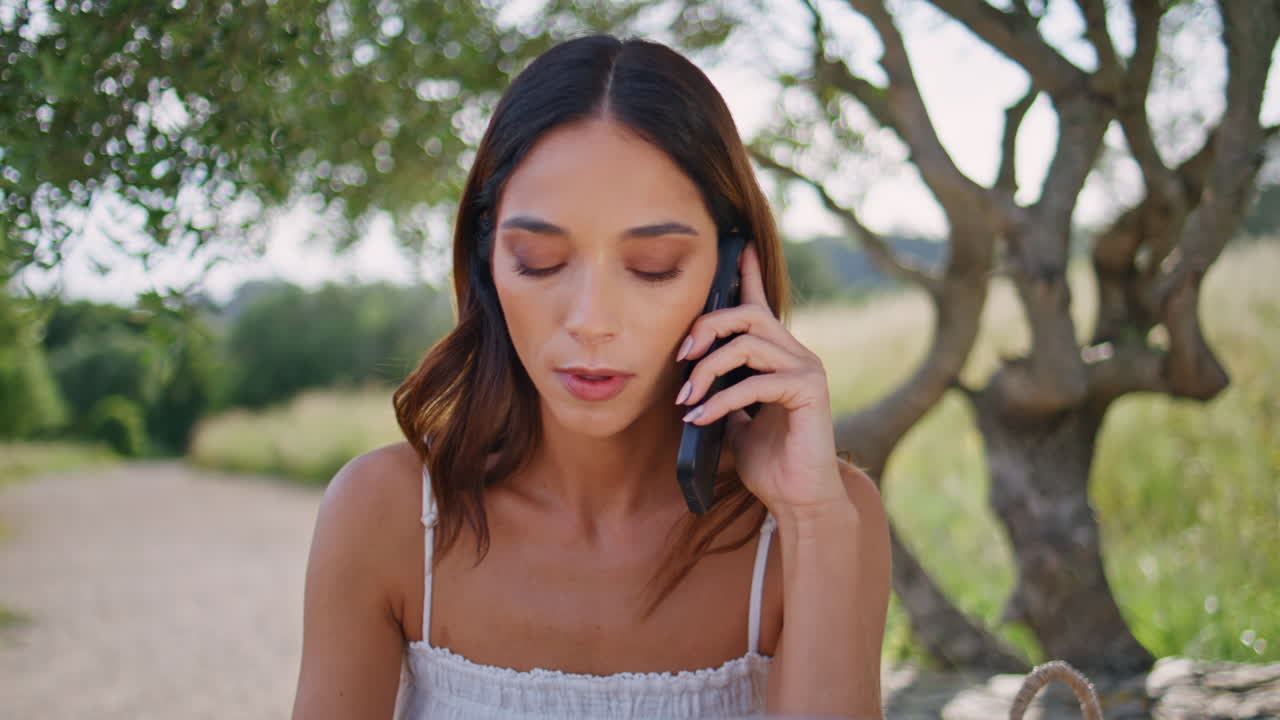 Serious lady talking mobile phone resting forest closeup. Woman feeling nervous