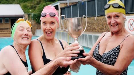 mujeres mayores felices sosteniendo el trofeo