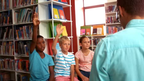 kids raising their hands in library