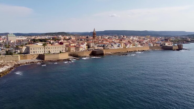 Clip con drone rivelatrice sulla pittoresca città di Alghero in Sardegna, Italia, con il centro storico e la cattedrale locale.