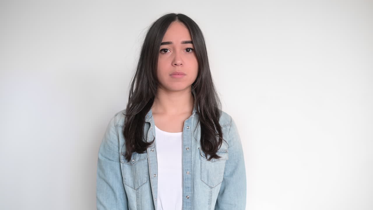 Girl is getting sad. Crossing hands. White background