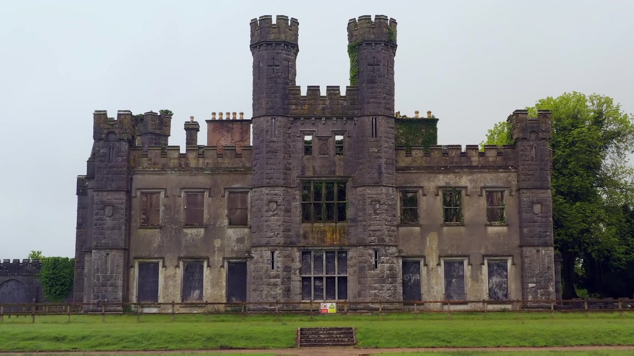 Symmetrische niedrige Drohnenfahrt, die sich Schloss Saunderson nähert und dessen architektonische Pracht sowie das Festungsmauerwerk enthüllt, Cavan, Irland.