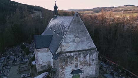 aerial view of the gothic church in velhartice and the surrounding sunlit hilly landscape