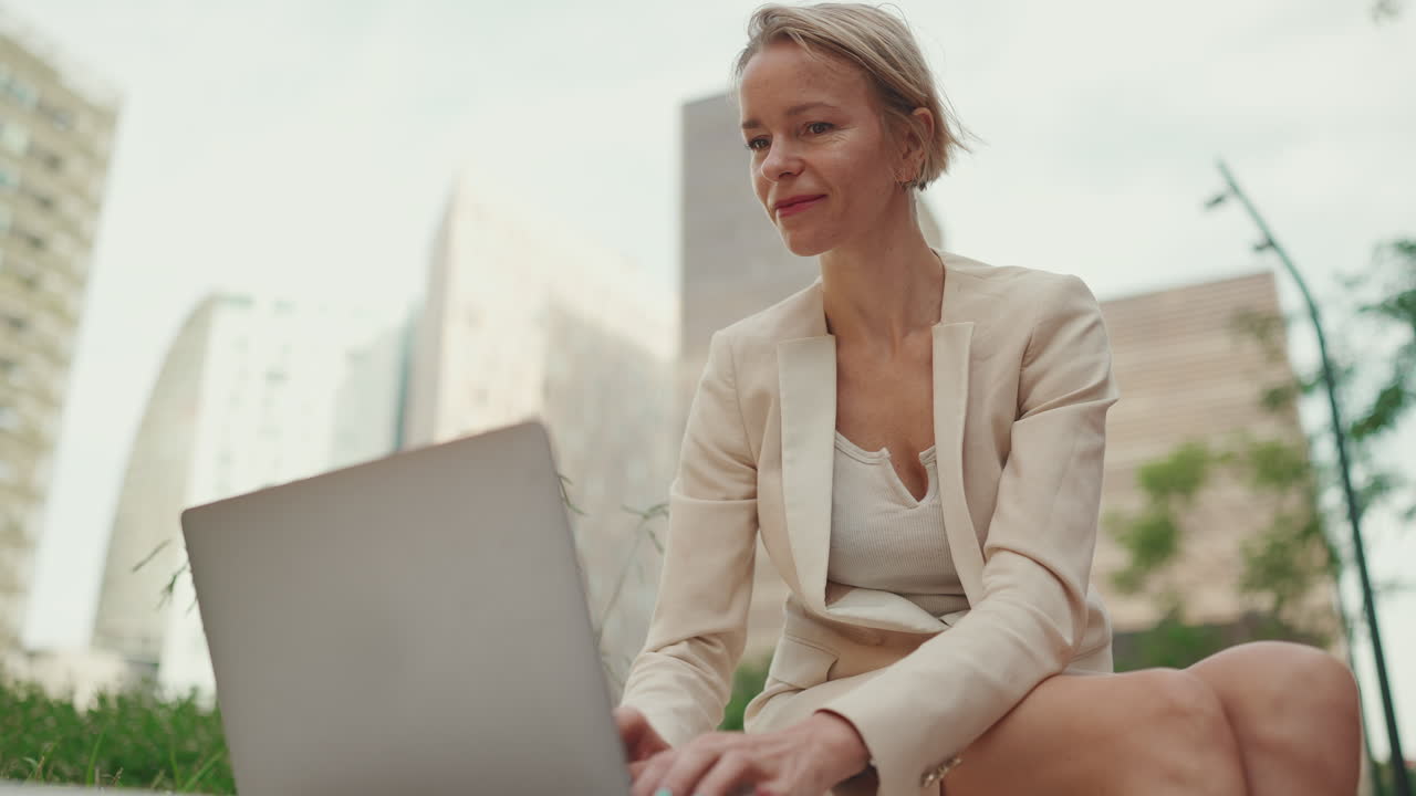 Businesswoman working on laptop outdoors