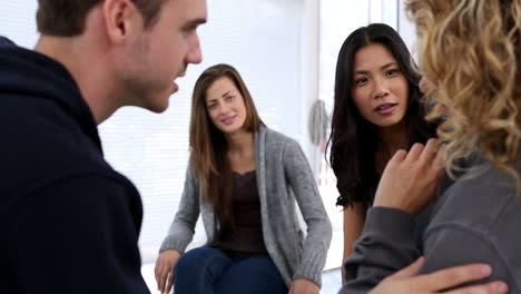 people comforting woman in a group therapy