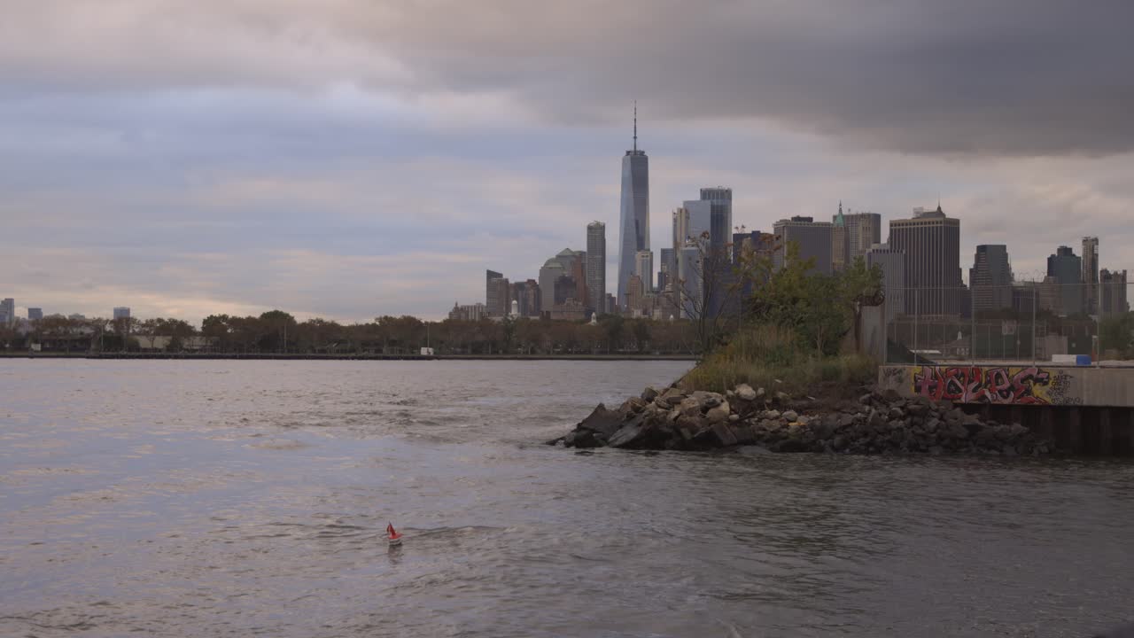 Man swimming in Bay of New York with city skyline background