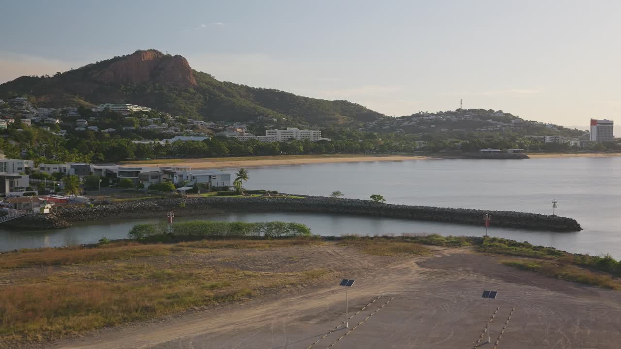 Pan right, Harbour and marina views at dawn on a beautiful clear morning with Castle Hill, Townsville and the sandy still beach in the background