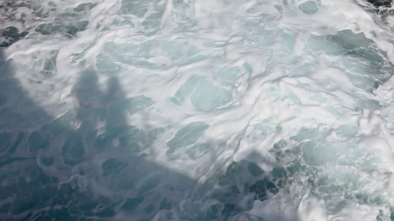 Campo lungo che cattura le ombre che si muovono rapidamente sull'acqua accanto al traghetto che viaggia da Calcutta a Port Blair, India