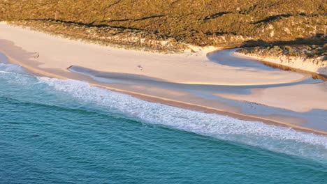 people walking along the beach at sunset in yallingup in western australia