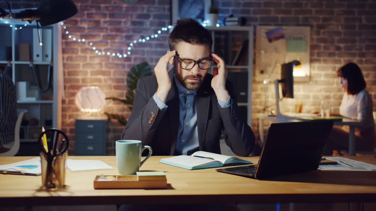 Overworked Businessman Suffering From Headache at Night