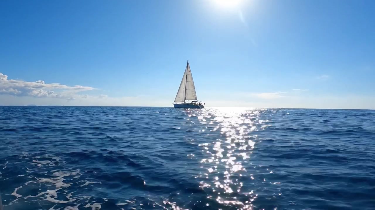 A Majestic Sailboat Gliding Through Crystal Clear Waters Under a Bright Blue Sky, Capturing the Essence of Nautical Freedom and Serenity in Every Wave