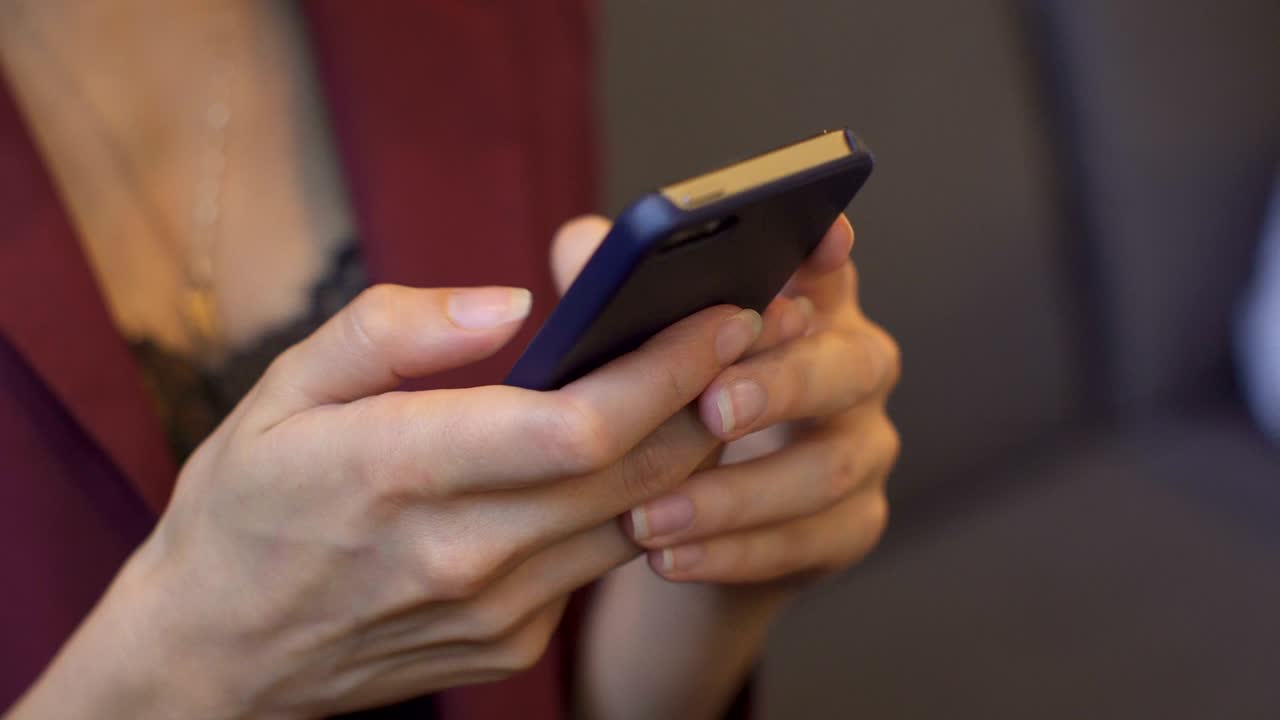 una mujer de negocios usando un teléfono inteligente en una cafetería.