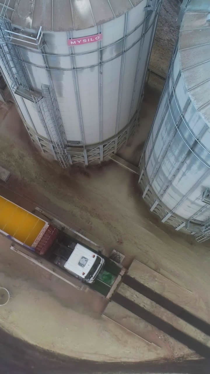Big steel elevator storage silos. Huge industrial elevator storages. Aerial view. Vertical video