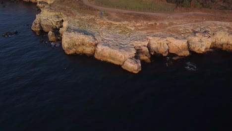 drone top down aerial view of waves splash against rocky seashore, background