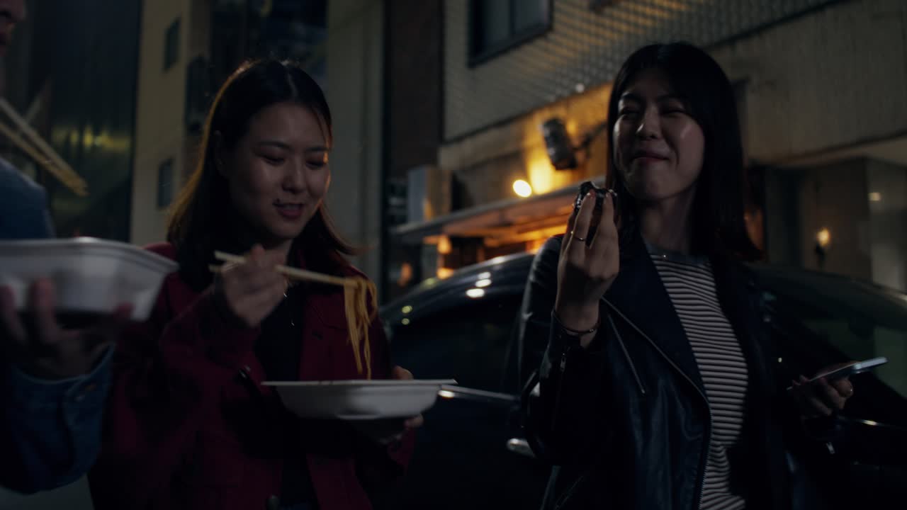 Friends Eating Noodles on a Night Street