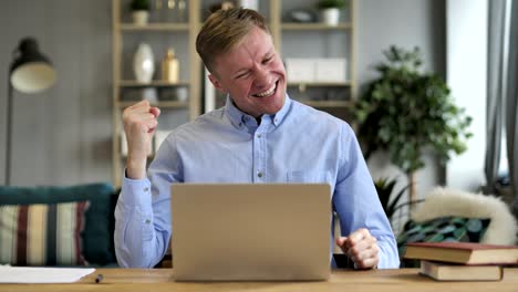 empresario emocionado celebrando el éxito, trabajando en una computadora portátil