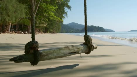 Playa-Tropical-De-Arena-Blanca-Con-Columpio-De-Cuerda,-Olas-Pequeñas-Y-árboles-Tropicales