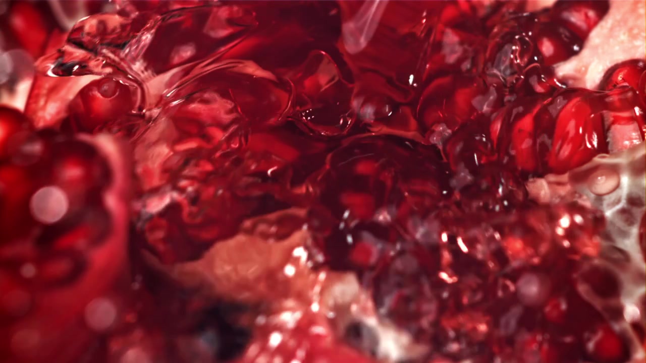 Slow Motion Close-Up of Red Pomegranate Seeds with Pouring Liquid