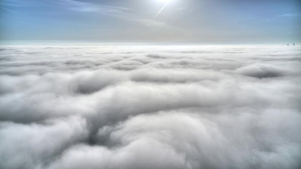 Aerial View of Dense Clouds Moving Under a Bright Sunny Sky