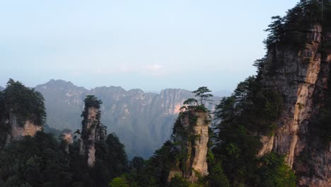 zhangjiajie mountain range with trees on top of it at sunset