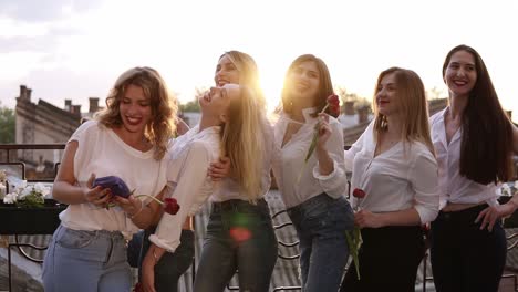 Beautiful,-glamour-women-in-jeans-and-white-shirts-on-a-terrace.-One-girl-trying-to-take-a-selfie-photo-of-all-the-women.-Stylish-caucasians.-Red-lipstick