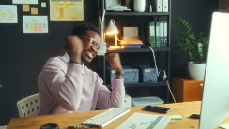 happy black man celebrating business achievement in office