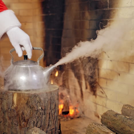 boiling retro aluminium kettle. teapot steams. santa claus takes a boiling kettle. closeup. teapot on a log.