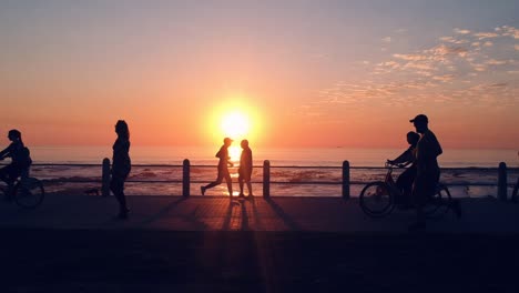 joggers on the promenade in cape town, south africa during sunset