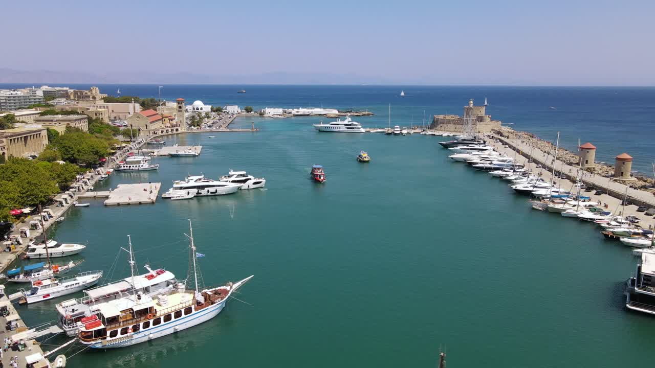 Pemandangan udara mengelilingi marina Mandraki di Rhodes, Yunani, dengan perahu-perahu yang mendekat.