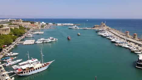 aerial orbit around marina mandraki in rhodes, greece with approaching boats