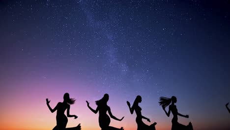 Silhouettes of four dancers under a starry sky at dusk