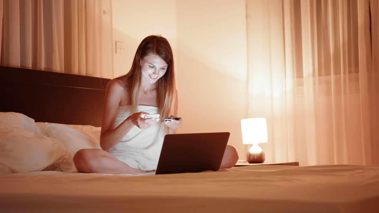 밤에 침대에서 온라인 쇼핑하는 여자